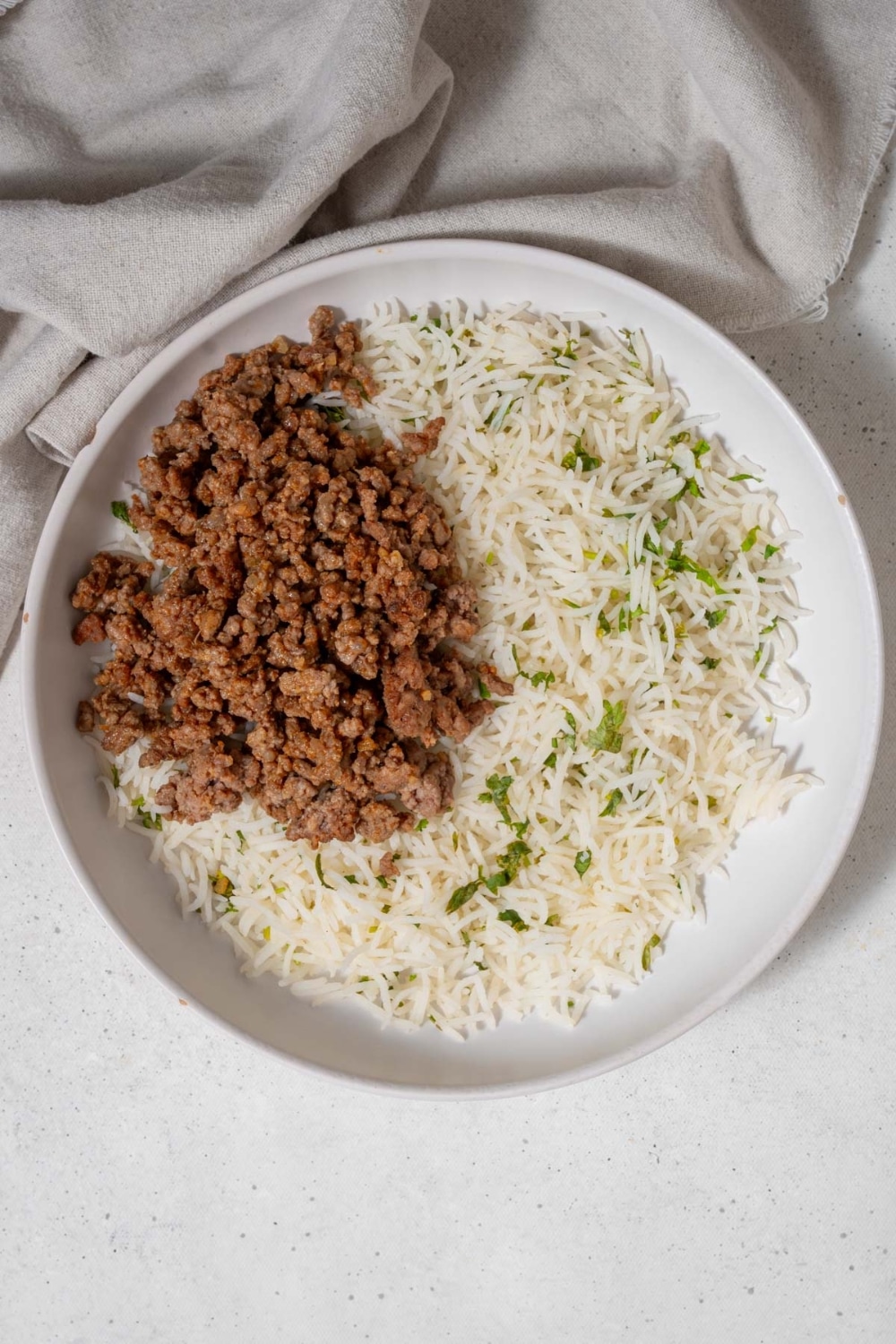 Cilantro lime rice topped with seasoned taco meat in a bowl.