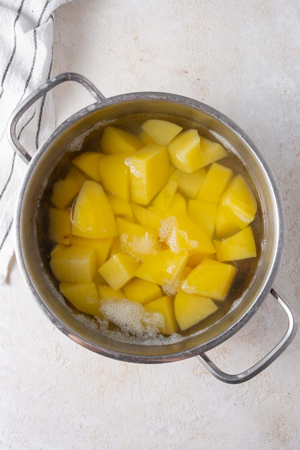 Potato chunks in a pot of water.