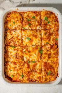 Million dollar spaghetti casserole cut into 12 squares.