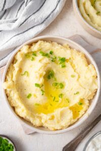 Creamy cottage cheese mashed potatoes in a bowl with chives and melted butter.