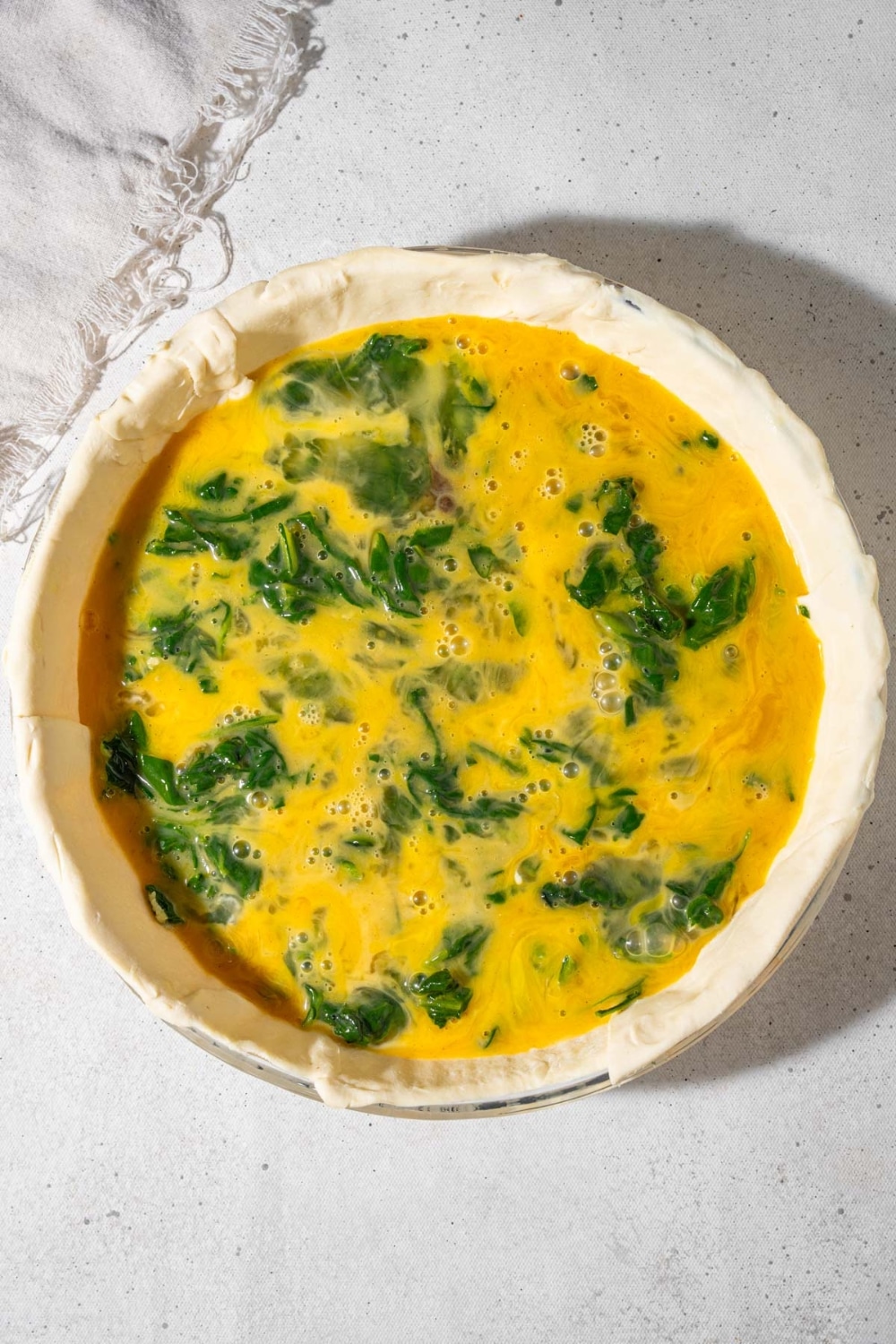 Raw eggs and fresh spinach in a puff pastry shell.